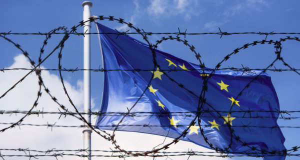 EU Flag and fence with barbed Wire. Foto: © Savvapanf Photo, Adobe Stock, 205271093