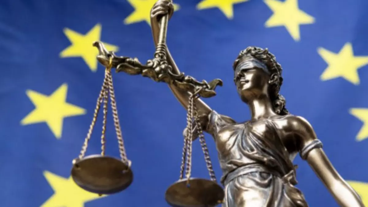 Statue of the blindfolded goddess of justice Themis or Justitia, against an European flag. Foto: respiro888, Adobe Stock, 224808539 Statue of the blindfolded goddess of justice Themis or Justitia, against an European flag. Foto: respiro888, Adobe Stock, 224808539
